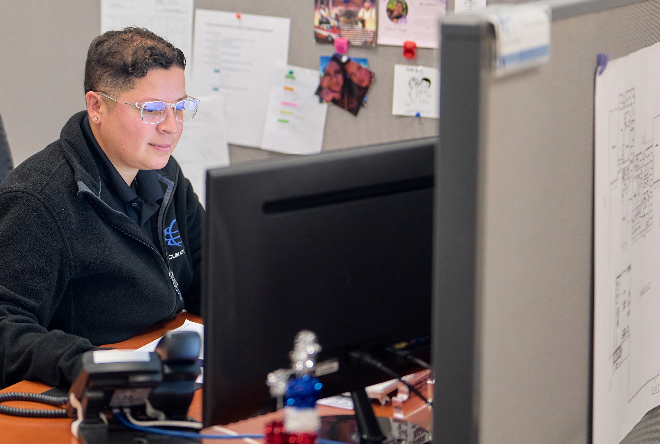 Office employee looking through reports on commercial refrigeration and HVAC clients